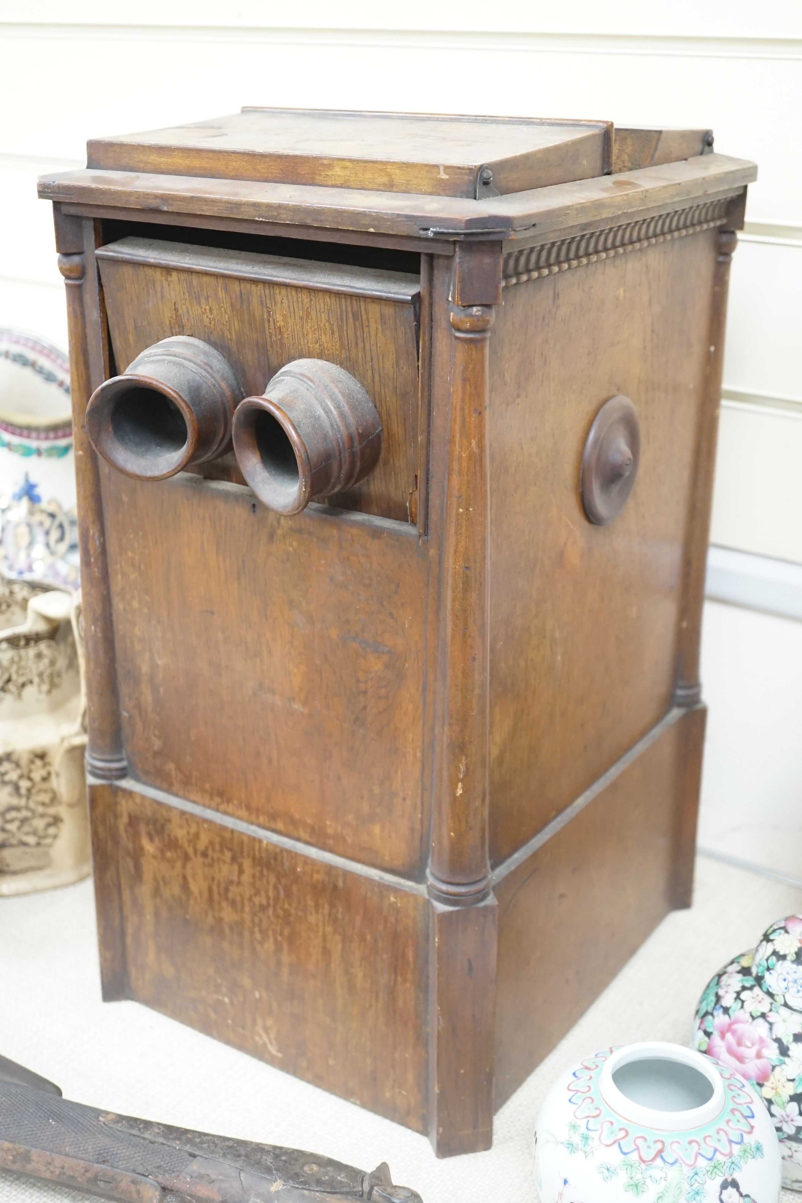 A late 19th century French walnut cased stereoscopic viewer, containing a quantity of stereographic photos, 46 cms high.